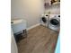 Functional laundry room with modern appliances, a utility sink, and ample space for folding and storage at 2445 Verde View Dr, Apopka, FL 32703