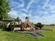 Community playground area featuring play structure with slides, and a lush green lawn against a blue sky at 2445 Verde View Dr, Apopka, FL 32703