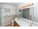 Bathroom featuring double sinks, a shower, and decorative wallpaper at 2621 Ardon Ave, Orlando, FL 32833