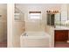 Well-lit bathroom with a soaking tub and vanity at 2621 Ardon Ave, Orlando, FL 32833