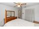 Bright bedroom with white walls, a ceiling fan, a dresser with mirror, and closet space, providing a serene retreat at 2621 Ardon Ave, Orlando, FL 32833