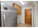 Bright laundry area with stainless steel refrigerator, wood cabinets and neutral flooring, with access to door and closets at 2621 Ardon Ave, Orlando, FL 32833
