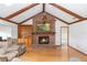 Cozy living room featuring a brick fireplace, hardwood floors, and vaulted ceilings at 2621 Ardon Ave, Orlando, FL 32833