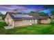 Exterior rear view of home with solar panels on roof, a well-maintained lawn, and attached garage at 2621 Ardon Ave, Orlando, FL 32833