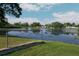 Picturesque backyard with a serene lake view framed by a chain-link fence and vibrant green grass at 3 Poinsettia Dr, Debary, FL 32713