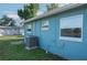 Side view of the house with blue exterior paint, white trim, AC unit, and well-maintained lawn at 3 Poinsettia Dr, Debary, FL 32713