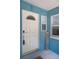 Charming home entrance featuring a white door, decorative glass, welcome sign, and textured turquoise exterior at 3 Poinsettia Dr, Debary, FL 32713