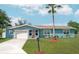 Charming single-story home with a well-manicured lawn, palm tree, and attached one car garage at 3 Poinsettia Dr, Debary, FL 32713