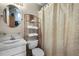 Cozy bathroom with a vanity, oval mirror, open shelving, and a shower featuring a patterned curtain at 3033 Zaharias Dr, Orlando, FL 32837