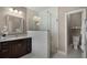 Bright bathroom featuring a walk-in shower with white tiling, dark wood vanity, and decorative flower arrangement at 3033 Zaharias Dr, Orlando, FL 32837