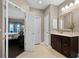 Neutral toned bathroom featuring a dark wood vanity with marble countertops and double door closet at 3033 Zaharias Dr, Orlando, FL 32837