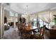 Formal dining room with a large table, elegant chandelier, and views into the living area at 3033 Zaharias Dr, Orlando, FL 32837