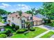 Spacious two-story home featuring lush landscaping, a three-car garage, and a red tile roof at 3033 Zaharias Dr, Orlando, FL 32837