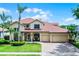Beautiful two-story home with a well-maintained lawn, three-car garage, and inviting front porch at 3033 Zaharias Dr, Orlando, FL 32837