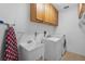 Functional laundry room with washer, dryer, sink, storage cabinets, and ironing board for convenience at 3033 Zaharias Dr, Orlando, FL 32837