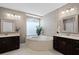 Bright bathroom with a soaking tub, dual vanities, modern lighting, and mosaic tile accents at 3033 Zaharias Dr, Orlando, FL 32837
