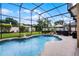 Beautiful screened-in pool with a well-maintained garden, lush landscaping, and outdoor cooking area at 3033 Zaharias Dr, Orlando, FL 32837
