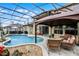 Relaxing screened-in pool area featuring a gazebo, stone accents, and comfortable seating for poolside lounging at 3033 Zaharias Dr, Orlando, FL 32837