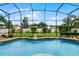 Sparkling screened-in pool area with a manicured lawn and landscaped garden, perfect for outdoor enjoyment at 3033 Zaharias Dr, Orlando, FL 32837