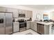 Kitchen featuring stainless steel appliances, grey cabinets, quartz countertops, and a seamless view into the living space at 3166 Skyline Loop, Kissimmee, FL 34758