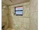 Nicely tiled shower with a window providing natural light, complete with soap dish, and shower head at 318 Douglas Way # 87, Winter Garden, FL 34787