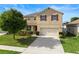 Two-story home featuring a two-car garage, well-manicured lawn, and charming red shutters at 3666 Maidencain St, Clermont, FL 34714