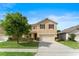 Charming two-story home with a well-manicured lawn, driveway, and attached two car garage at 3666 Maidencain St, Clermont, FL 34714