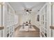 Bright home office featuring glass French doors, modern desk, and ceiling fan at 3666 Maidencain St, Clermont, FL 34714