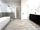 Bathroom featuring a standalone tub, glass-enclosed shower, and modern dark vanity at 3764 Rachel St, Apopka, FL 32703