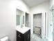 Bathroom with black vanity, quartz countertop, a large mirror, and a linen closet at 3764 Rachel St, Apopka, FL 32703