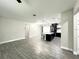 Open-concept living room featuring wood-look tile floors and seamless flow into the modern kitchen and dining area at 3764 Rachel St, Apopka, FL 32703