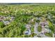 Lush aerial view showcases the neighborhood and a home with solar panels surrounded by mature trees at 381 Red Mulberry Ct, Longwood, FL 32779