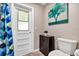 This well-lit bathroom has a windowed door, blue patterned shower curtain, and a cabinet with doors at 381 Red Mulberry Ct, Longwood, FL 32779