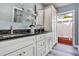 Bathroom featuring dual vanity with granite countertop, white cabinets, and a view to the backyard at 381 Red Mulberry Ct, Longwood, FL 32779