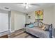 This cozy bedroom has a ceiling fan, grey laminate wood flooring, and closet with white louvered doors at 381 Red Mulberry Ct, Longwood, FL 32779