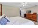 Comfortable bedroom featuring a ceiling fan, wood dresser, and a walk-in closet for ample storage at 381 Red Mulberry Ct, Longwood, FL 32779