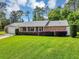 Classic single-story brick home featuring a well-manicured lawn and a two-car garage at 381 Red Mulberry Ct, Longwood, FL 32779