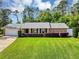 Charming single-story brick home featuring a well-maintained lawn and a two-car garage at 381 Red Mulberry Ct, Longwood, FL 32779