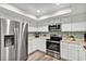 Bright kitchen with stainless steel appliances, white cabinetry, and tiled backsplash for a modern look at 381 Red Mulberry Ct, Longwood, FL 32779