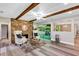 Light-filled living room with brick fireplace, exposed beam ceiling and view to back patio at 381 Red Mulberry Ct, Longwood, FL 32779