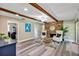 Spacious living room features exposed wood beams, brick fireplace, and wood-look flooring at 381 Red Mulberry Ct, Longwood, FL 32779
