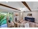 Open-concept living room with exposed beam ceiling, access to screened patio and updated flooring at 381 Red Mulberry Ct, Longwood, FL 32779
