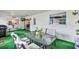 Screened-in porch with table and chairs overlooking the yard, complete with green carpet and bright lighting at 381 Red Mulberry Ct, Longwood, FL 32779