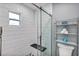 Modern shower with sleek glass door, white tiled walls, and convenient built-in bench seating at 381 Red Mulberry Ct, Longwood, FL 32779