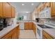 Functional kitchen with wooden cabinets, tile flooring, and white appliances at 4951 Alita Ter, St Cloud, FL 34769