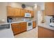 Well-lit kitchen with white appliances, tiled floor, wooden cabinets and ample counter space at 4951 Alita Ter, St Cloud, FL 34769