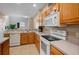 Practical kitchen with wooden cabinets, white appliances, and ample counter space for meal prep at 4951 Alita Ter, St Cloud, FL 34769