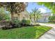 Charming home with a well-manicured lawn, fresh mulch, and decorative palm trees at 5044 Wise Bird Dr, Windermere, FL 34786
