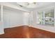 Spacious living area with hardwood flooring, neutral walls, large windows, and modern ceiling fan at 5044 Wise Bird Dr, Windermere, FL 34786