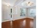 Bright living room featuring hardwood floors, a modern ceiling fan, and large windows for natural light at 5044 Wise Bird Dr, Windermere, FL 34786